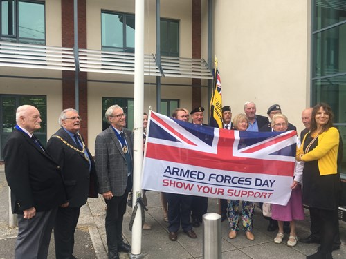 Councillors Les Cruwys and Colin Slade with members of the armed forces raising the flag on Armed Forces Day