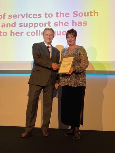Image of Jackie receiving her award presented by AEA Chief Executive, Peter Stanyon