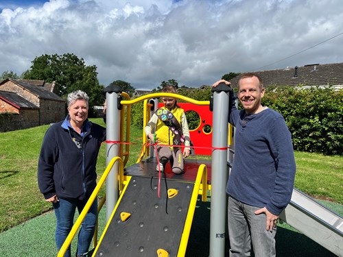 Judith Stewart (1st Willand Brownies), Seren, and Councillor Dave Wulff with the new equipment in Pippins Field Play Park, Uffculme.